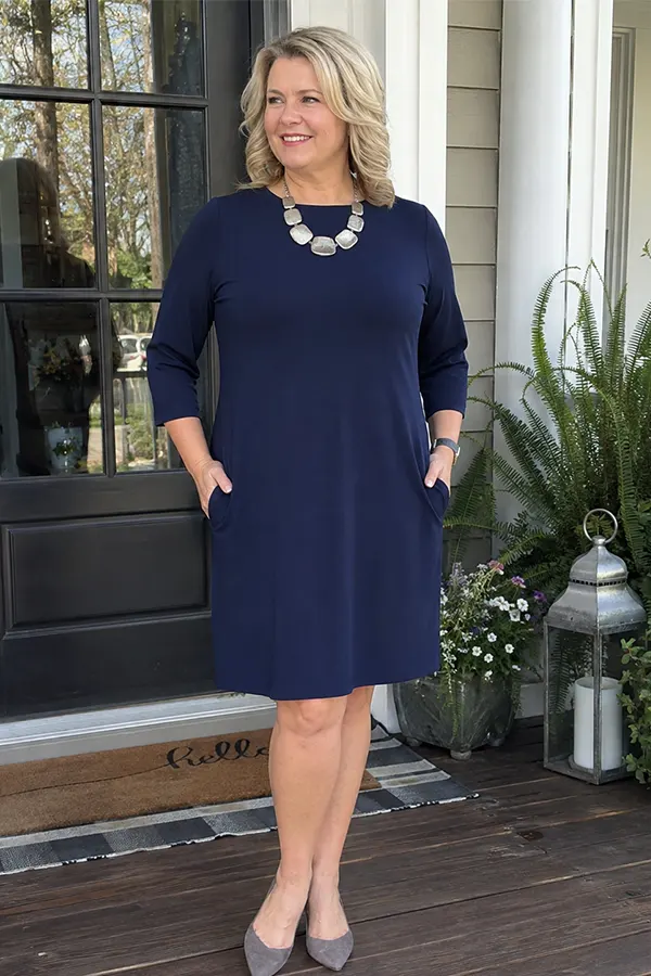 A Navy Short Sleeve Dress With A Statement Necklace