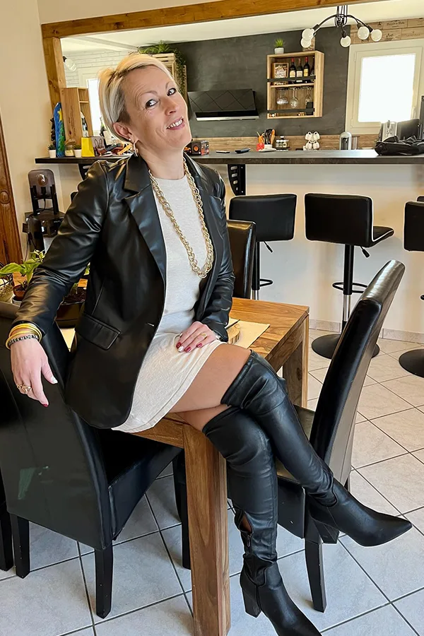 Layer A Leather Jacket Over A Light Dress With Tall Boots