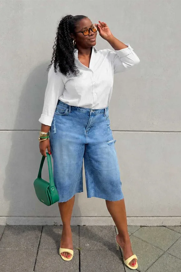 White Blouse With Blue Jorts And A Green Handbag